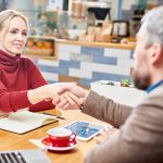 a business owner shaking hands with a customer, demonstrating the power of human-centric marketing