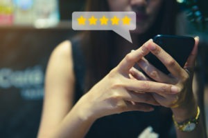 a woman on her phone demonstrating the power of reviews